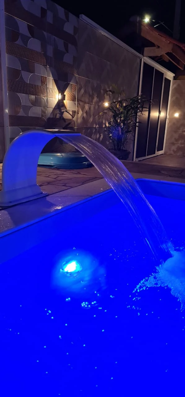 Piscina iluminada à noite no Lar dos Sonhos