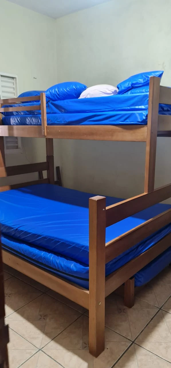Quarto com beliches de madeira e roupa de cama azul